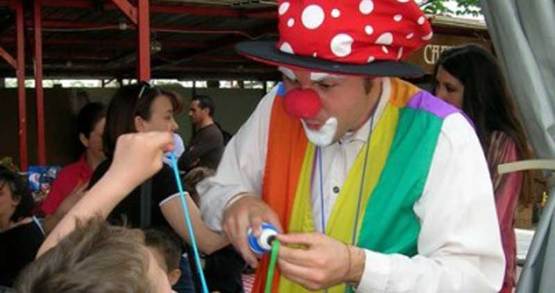 Un clown fa divertire un gruppo di bambini